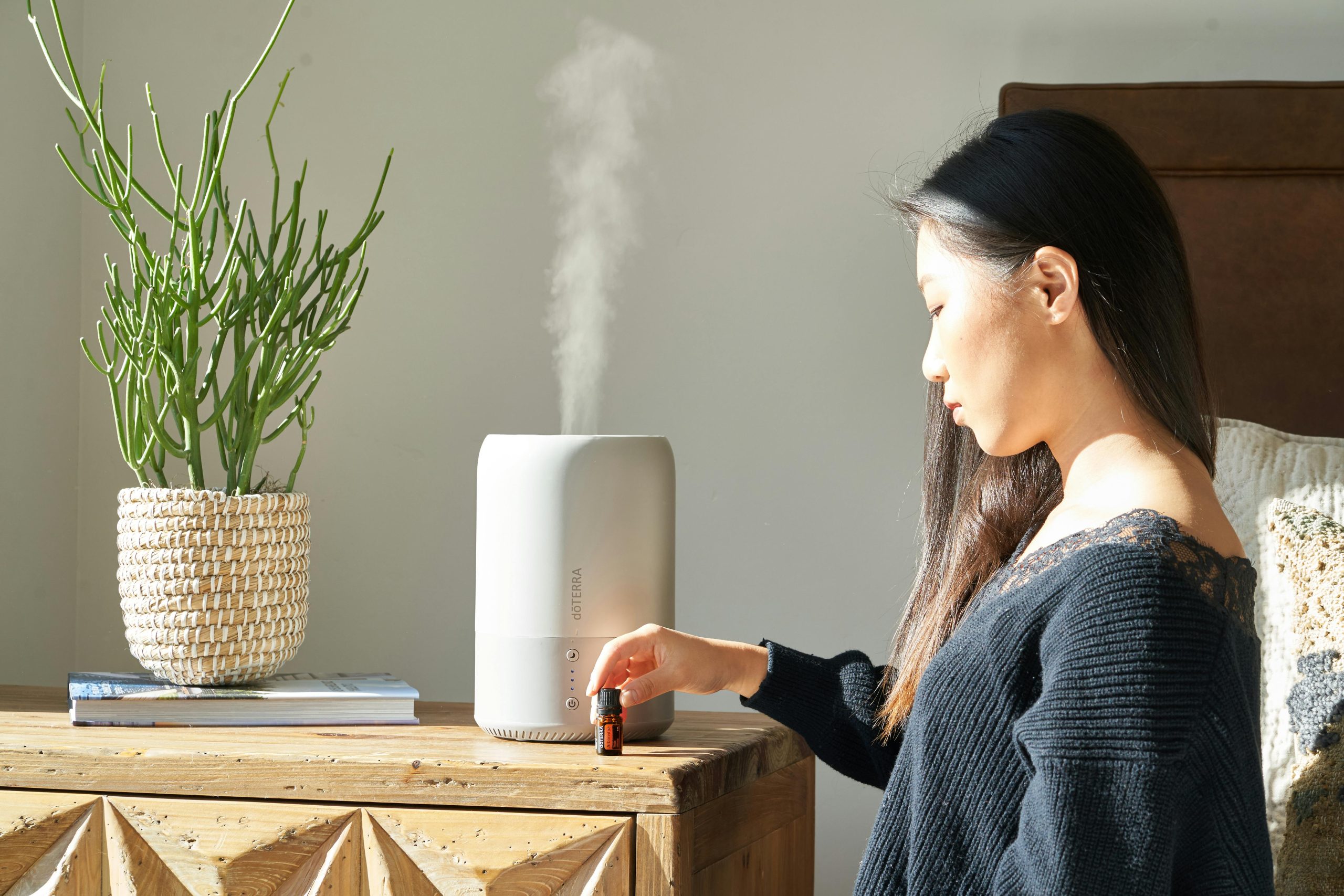 woman sitting next to diffuser best home scents blog