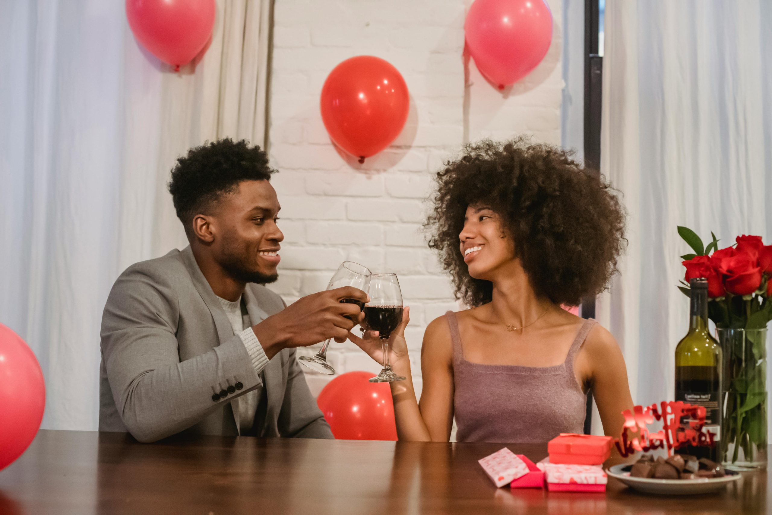 black couple sitting at table with wine at-home date night ideas the reef apartments jacksonville blog