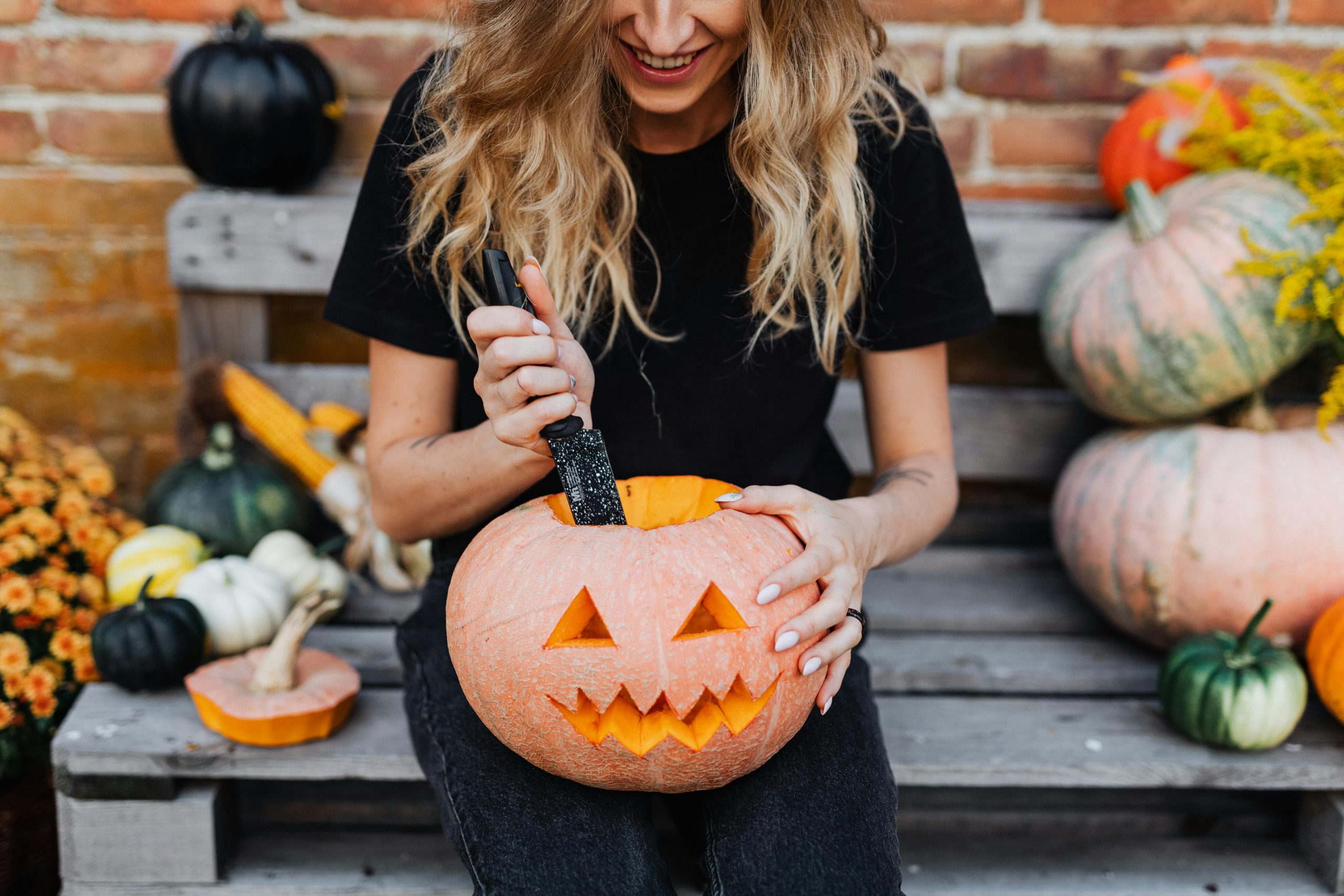 woman carving pumpkin the reef blog fall activities jacksonville